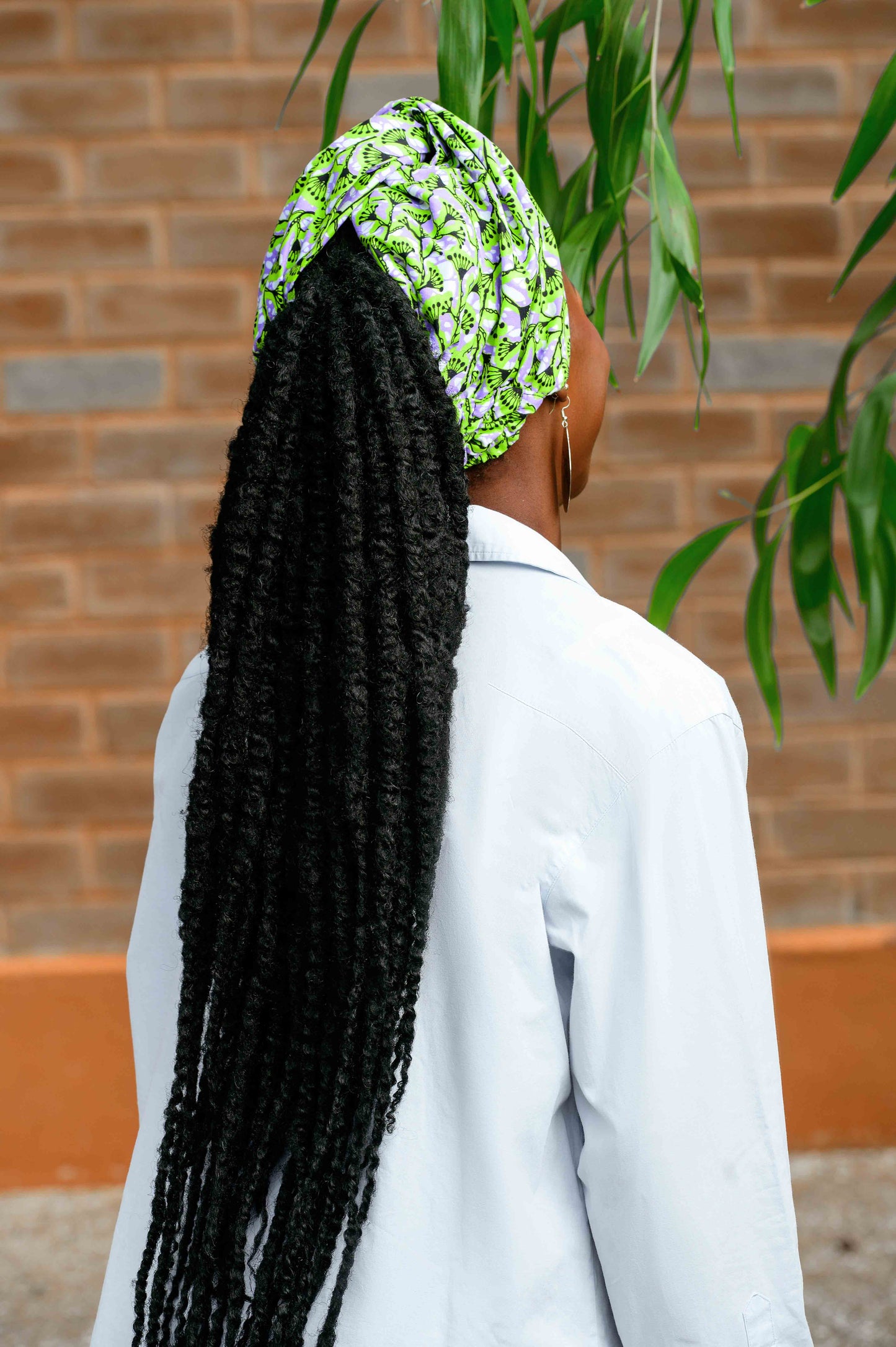 Vue de dos du foulard pré-noué 2-en-1 FAFA, porté en turban. Son système d'attache discret assure un maintien optimal tout en offrant un style chic et couvrant. Ce foulard est une pièce unique, idéale pour celles qui cherchent à intégrer des motifs wax dans leur garde-robe avec élégance.