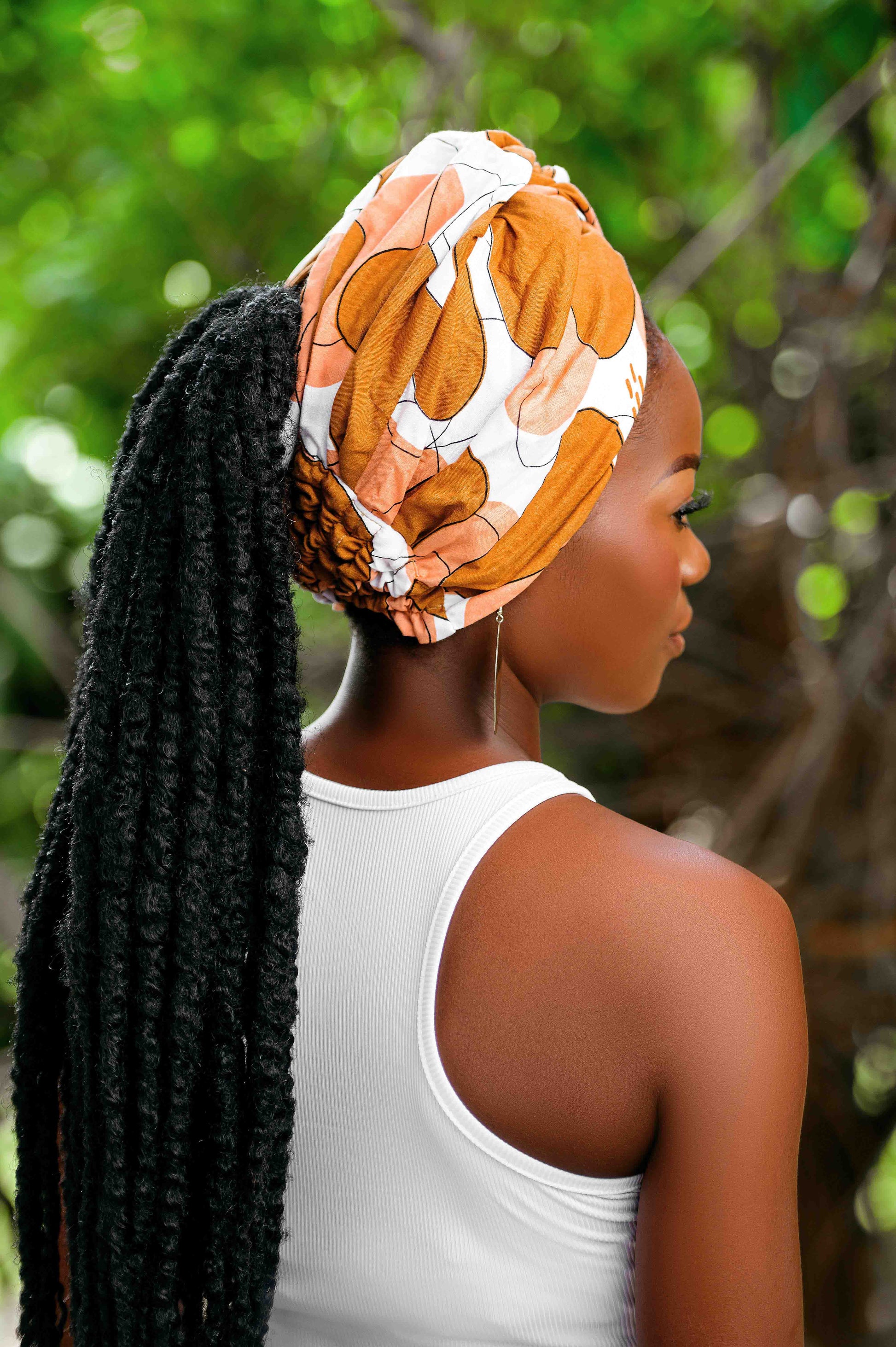 Vue de dos du foulard Didjo marron nude, pré-noué et porté en turban avec une queue de cheval, soulignant son style chic et tendance.