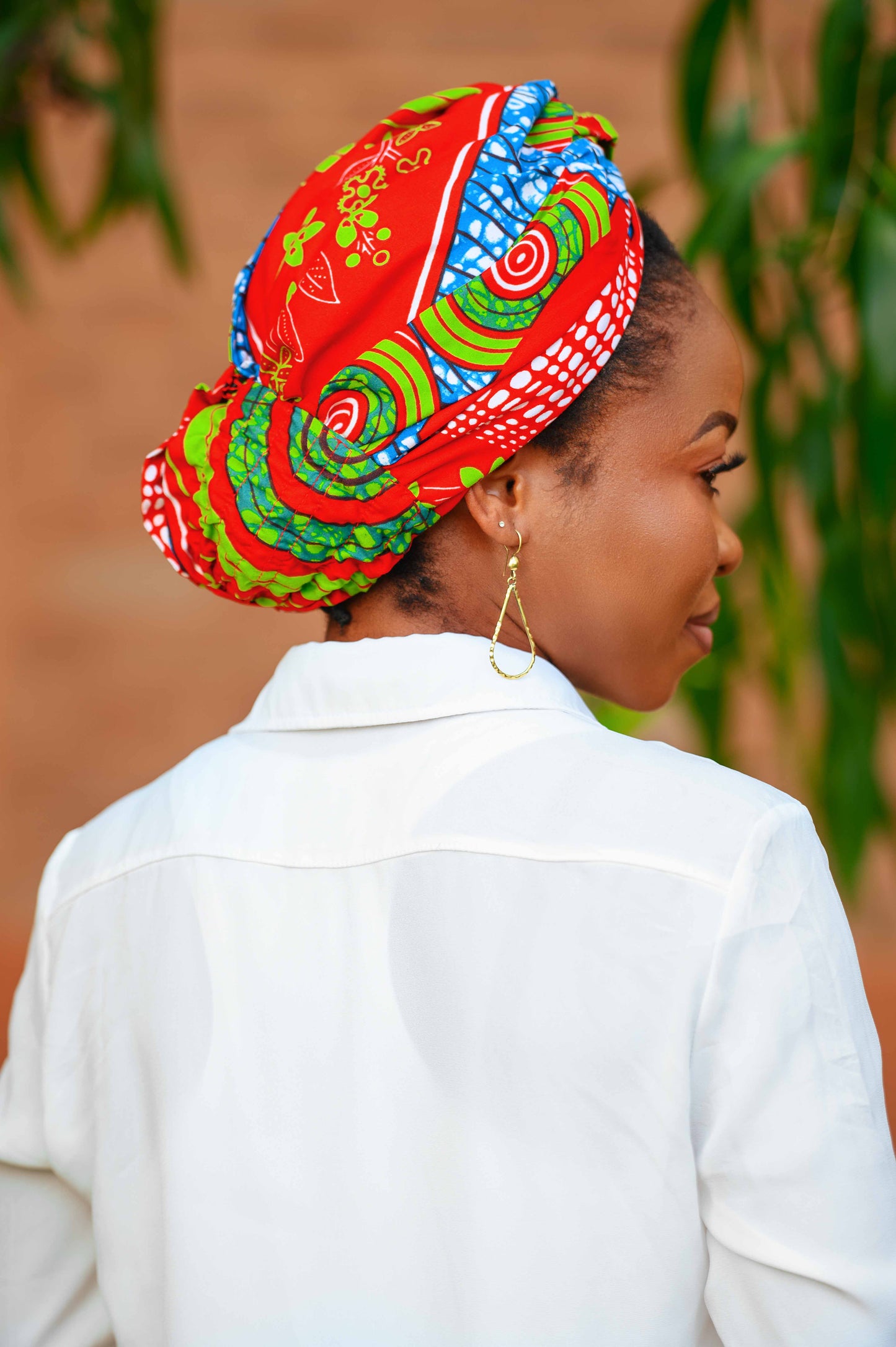 Vue de dos du foulard pré-noué 2-en-1 LONLON, porté en turban. Avec un système d'attache discret, ce foulard offre une couverture élégante tout en restant confortable. Sa couleur rouge éclatante et ses motifs uniques en font une pièce rare dans votre garde-robe