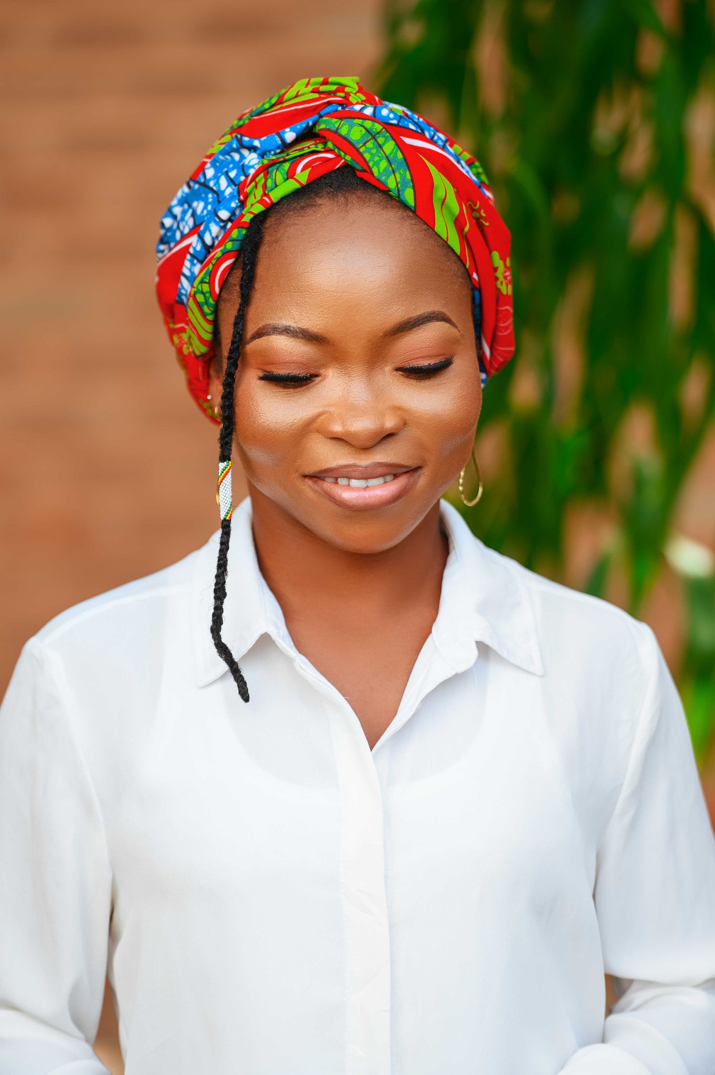 Découvrez le foulard pré-noué 2-en-1 LONLON, présenté de face. Fabriqué à la main au Togo en 100 % coton, ce foulard modulable se porte en bandeau ou en turban. Avec ses couleurs éclatantes de rouge, bleu azur et vert pomme, il ajoute une touche vibrante à tous vos looks.