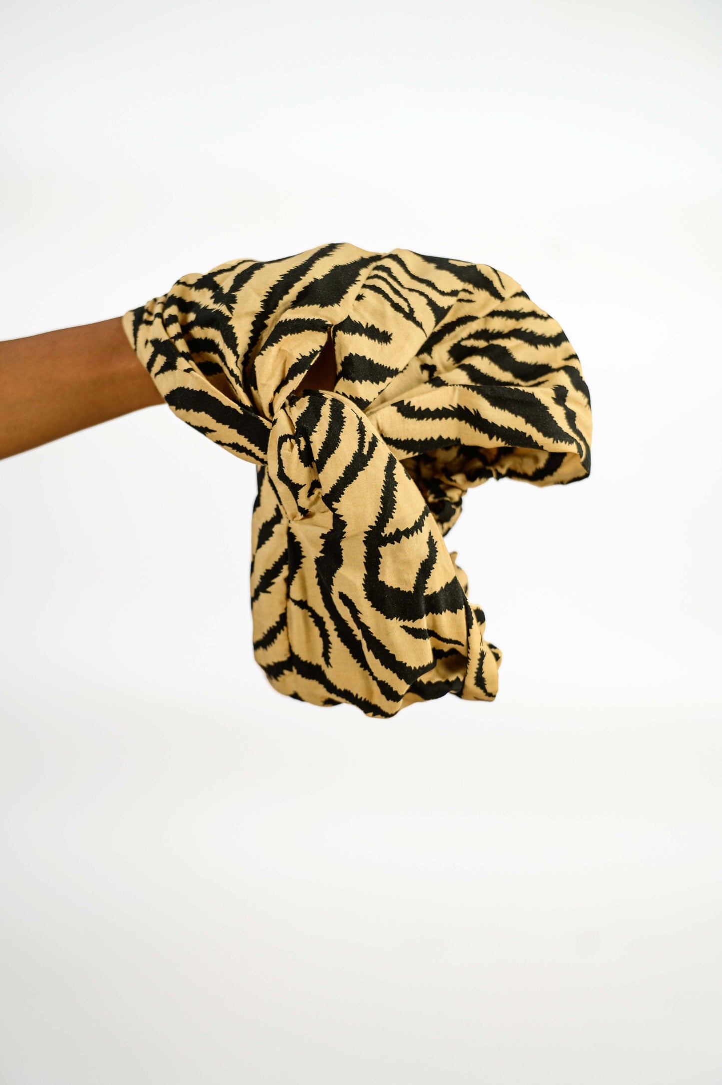 Le foulard pré-noué 2-en-1 NAVI accroché, mettant en avant sa belle teinte camel et son design élégant. Fabriqué en 100 % coton, ce foulard artisanal est idéal pour ajouter une touche subtile de couleur à votre collection d'accessoires. Une pièce d’édition limitée à ne pas manquer !