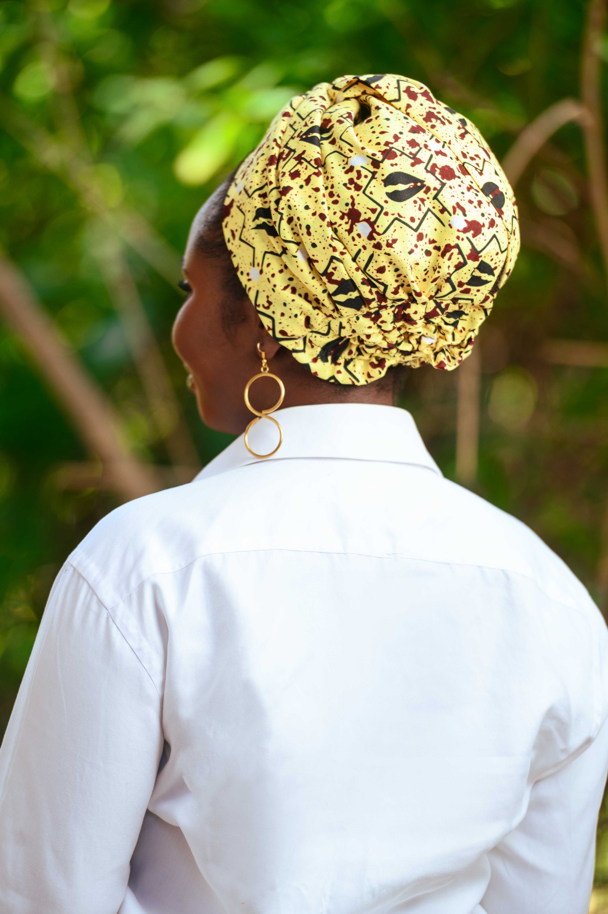 Vue de dos du foulard pré-noué SIKA, porté en turban. Avec un système d'attache discret, ce foulard offre une couverture chic et confortable. Chaque pièce, fabriquée à la main, est unique et idéale pour apporter une touche d'originalité à votre garde-robe.