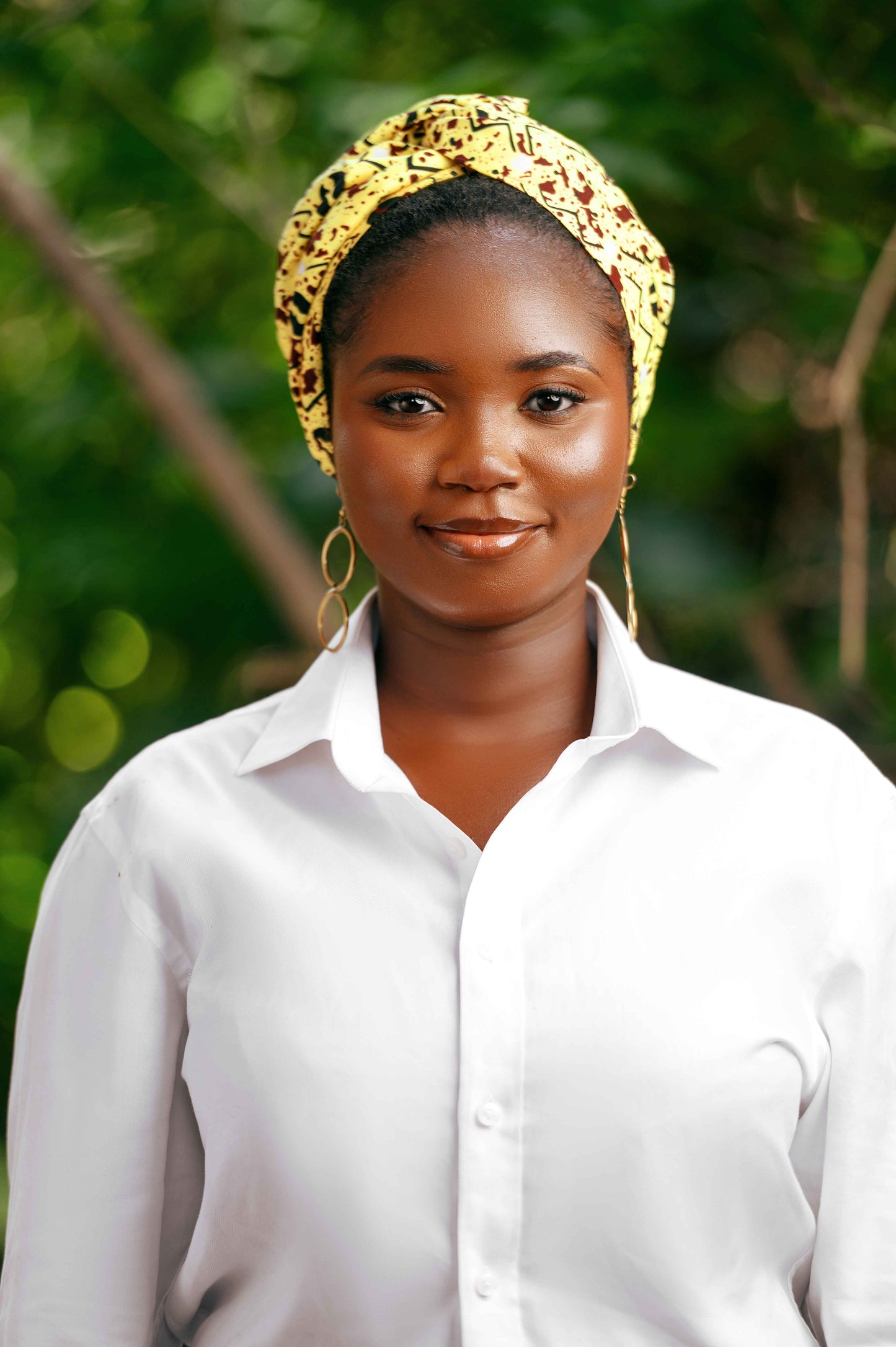 Découvrez le foulard pré-noué SIKA porté en face, un accessoire 2-en-1 qui se transforme facilement en bandeau ou en turban. Fabriqué à la main au Togo, ce foulard en 100 % coton arbore des motifs uniques inspirés de l'art africain, ajoutant une touche authentique à votre look.